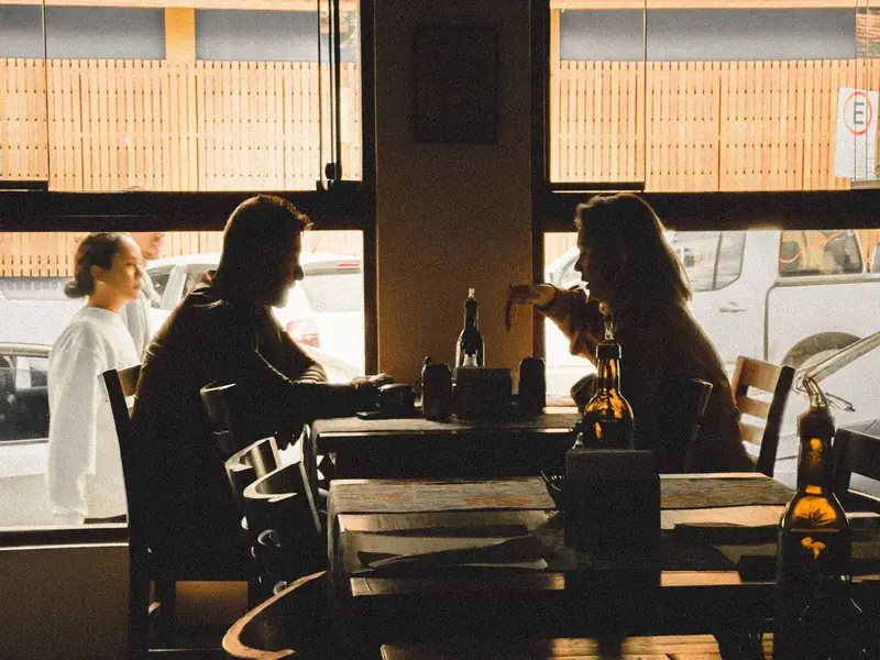 Silhouetted couple dining by a restaurant window