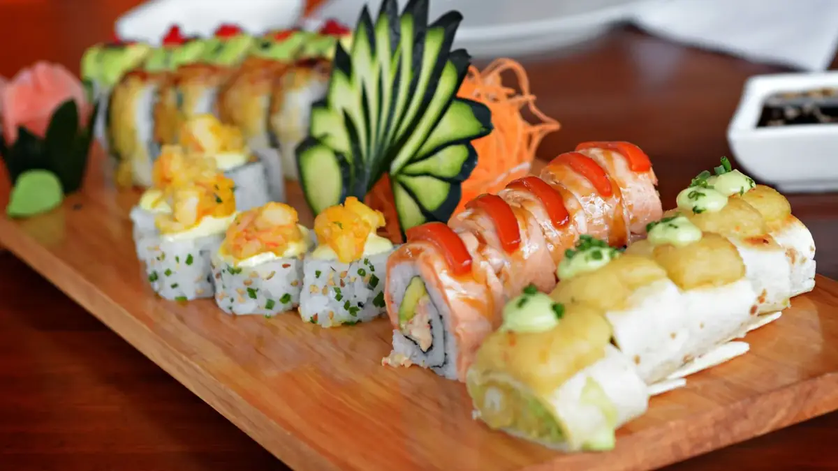 Platter of assorted sushi rolls on a wooden board