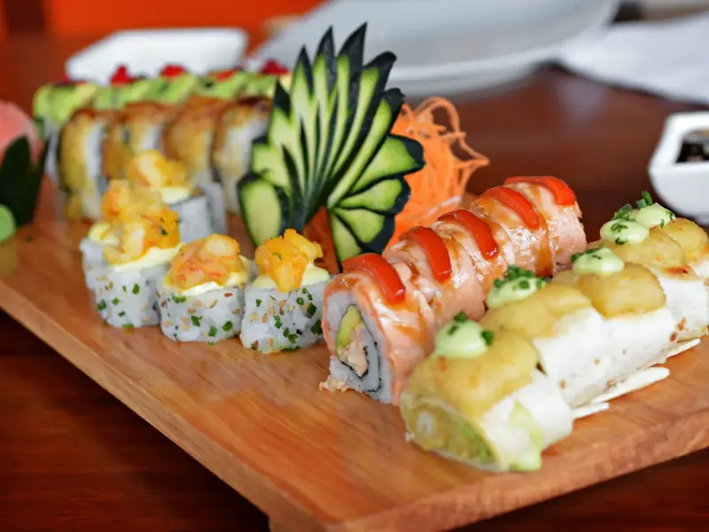 Platter of assorted sushi rolls on a wooden board